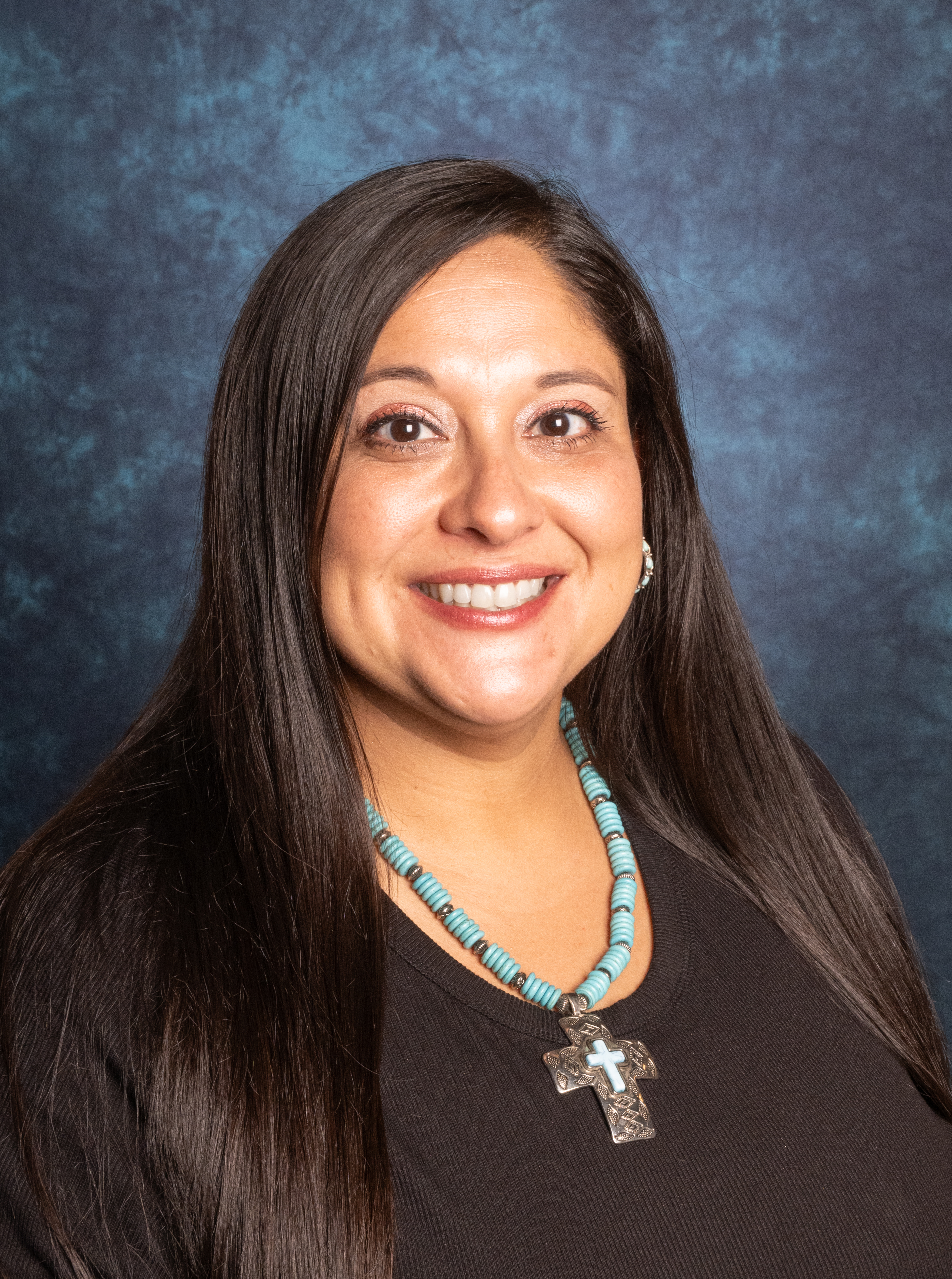 woman smiling for photo with black shirt and necklace